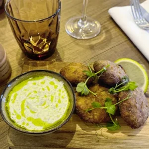 Plat de la mer, galettes dorées à base d’anchois, pommes de terre et sauce fraîche au citron